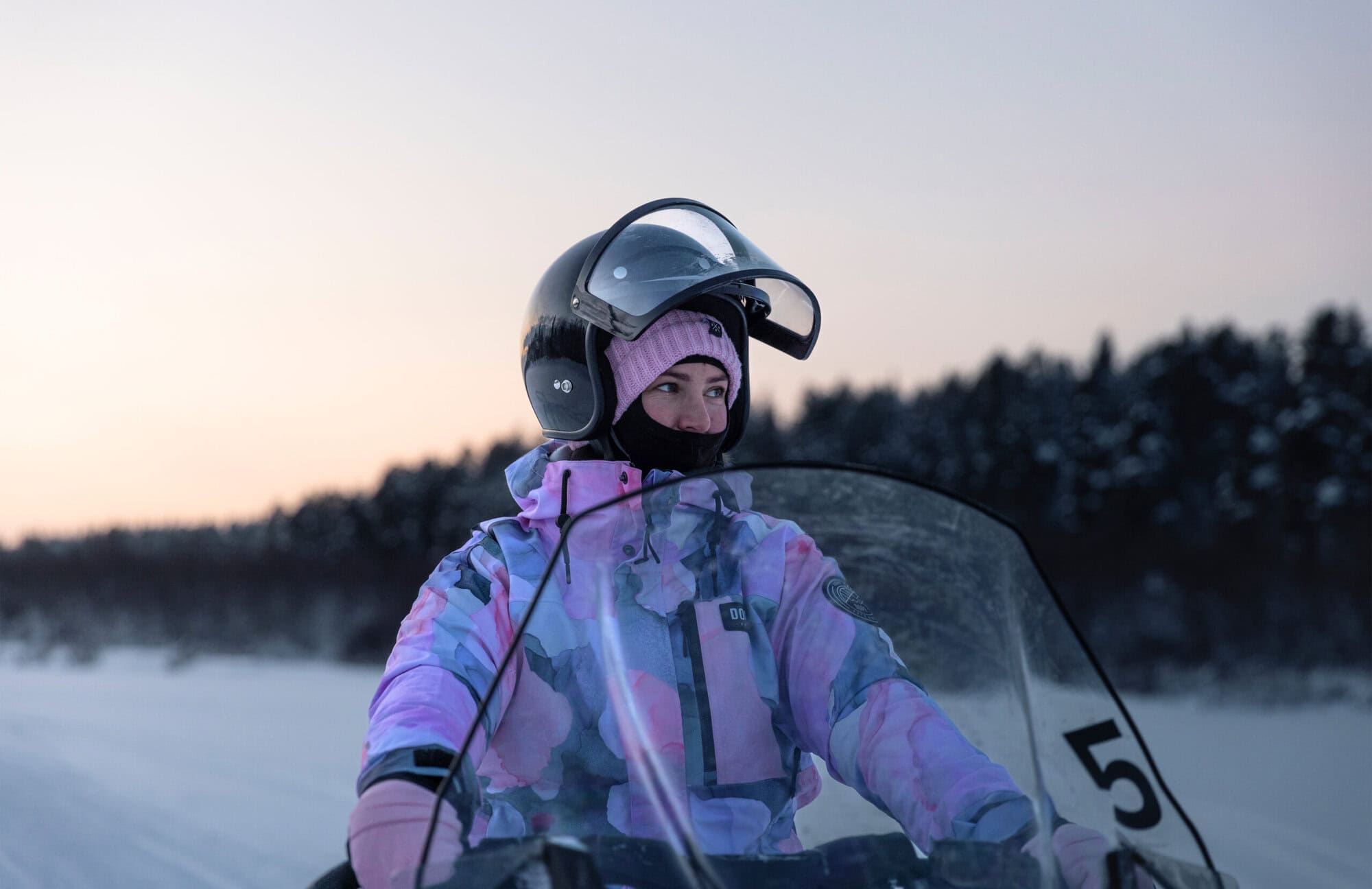 Snowmobile tour through a snowy forest at Aurora Village