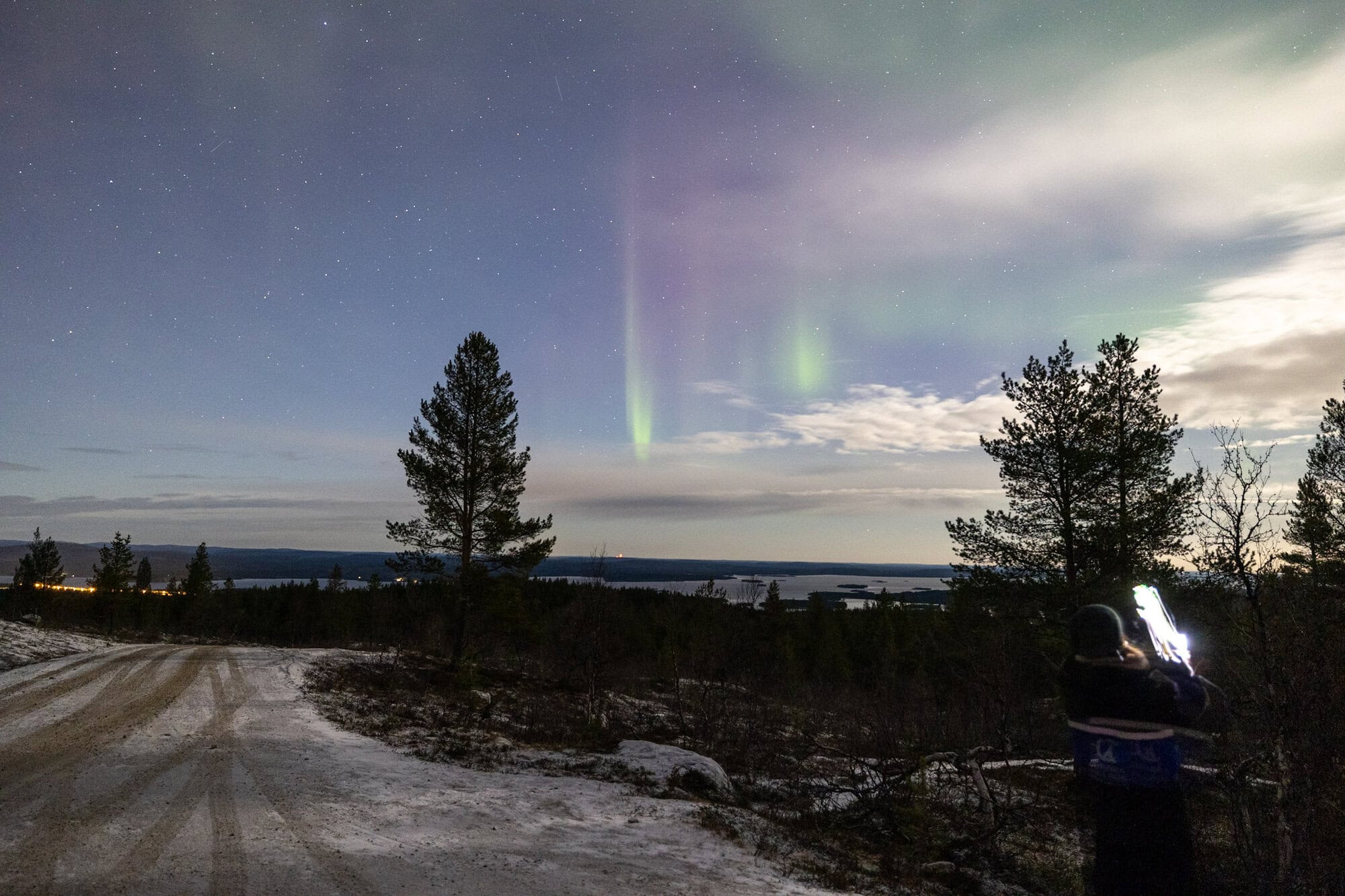 Northern Lights over a lightly snow-covered landscape during an Aurora tour in Ivalo on 10 November 2025