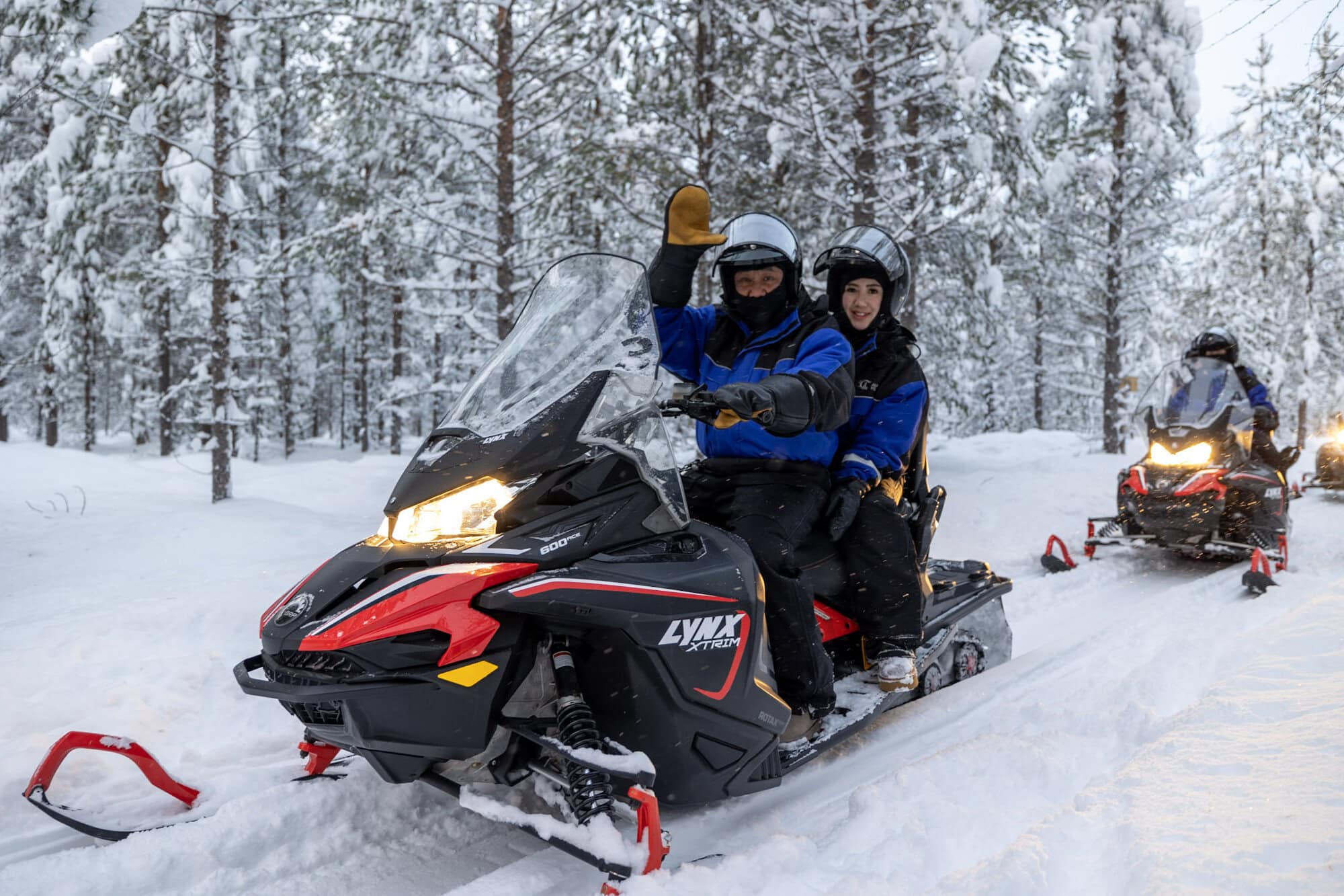 Guests riding snowmobiles through a snowy forest in Ivalo on 23 November 2024