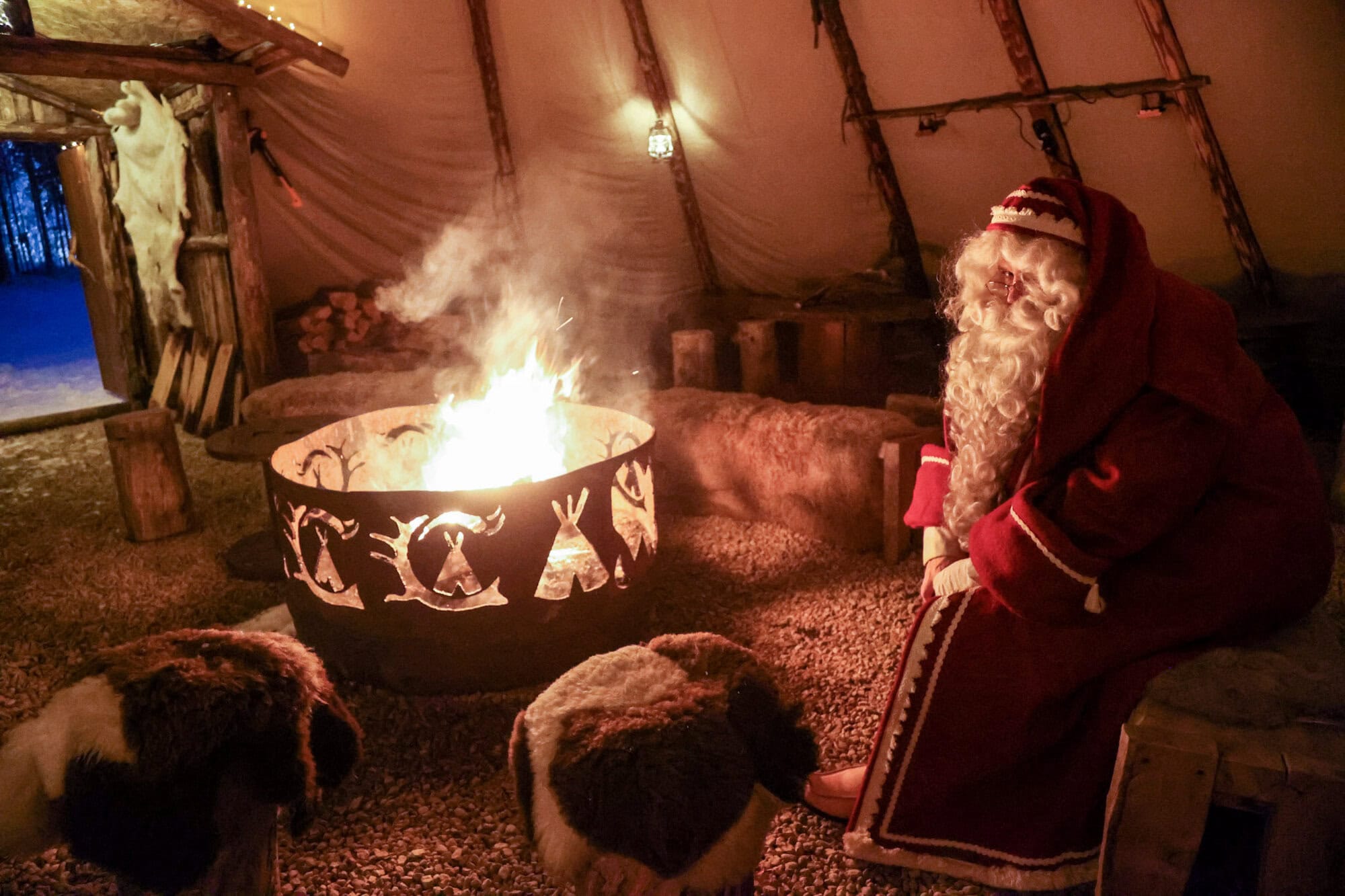 Santa Claus beside a fire inside a traditional kota at Aurora Village on 25 November 2024