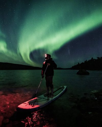 Floating under the aurora in Ivalo Lapland Finland.